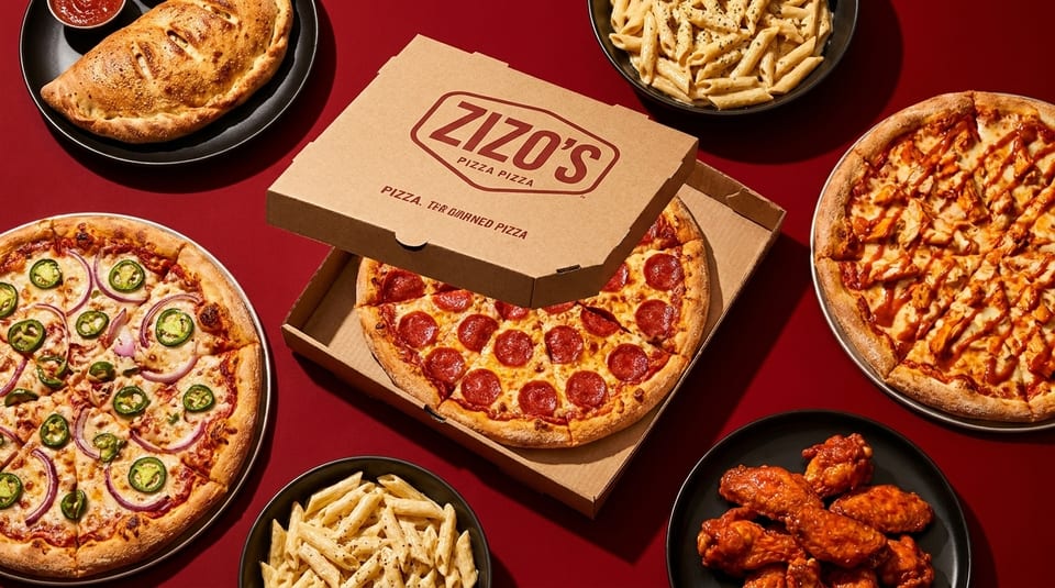 Zizo's pepperoni pizza in a box, two other pizzas, pasta, wings, and a calzone on a red background.